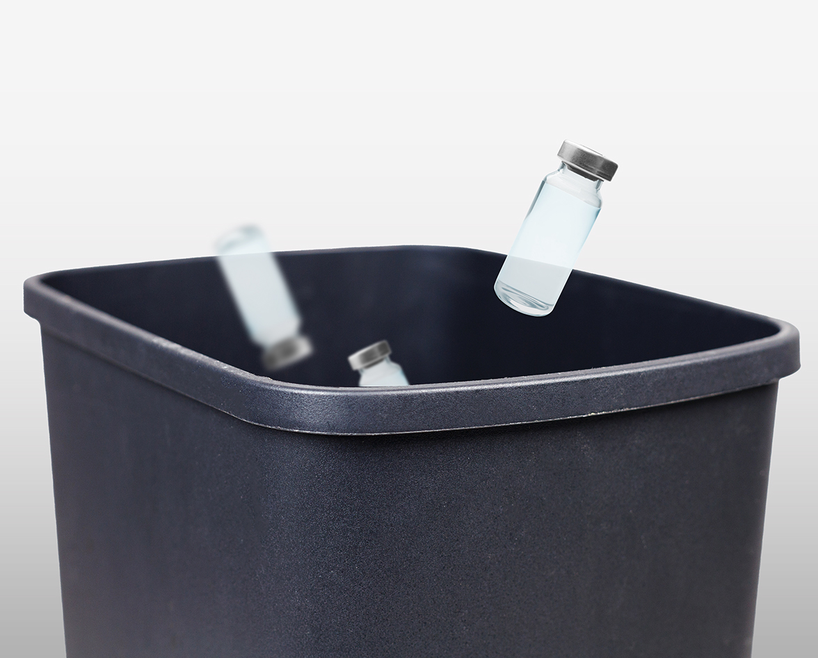 Medicine vials falling into a garbage can